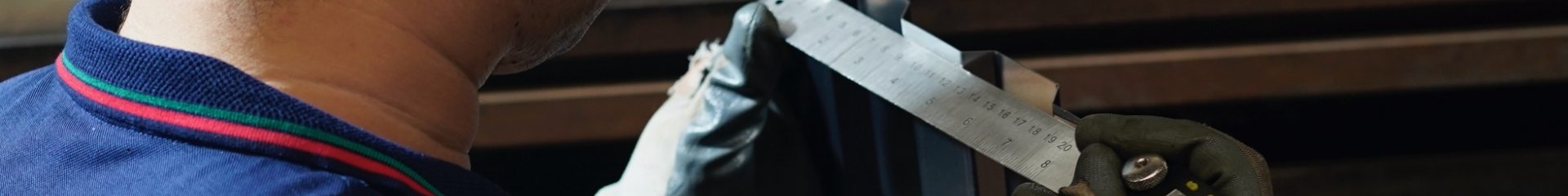 Der Arbeiter überprüft die interne Größe der Spalte mit einem Lineal.